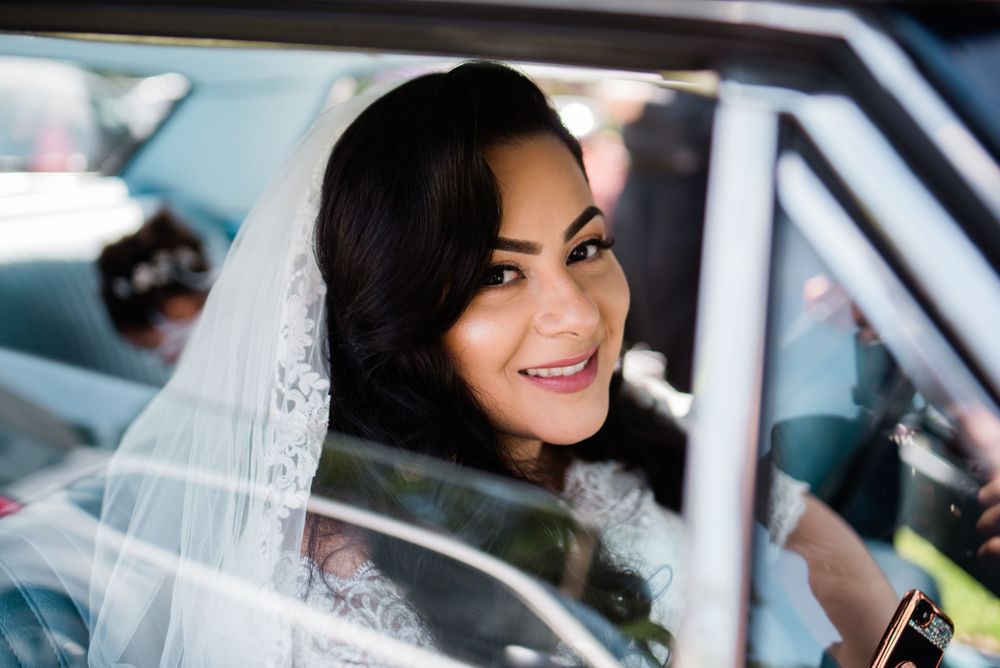 bride smiling sitting inside vintage car