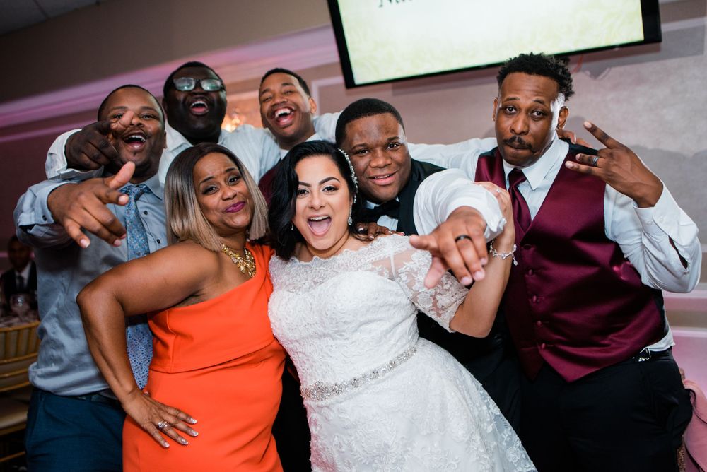 bride and groom posing with wedding guest