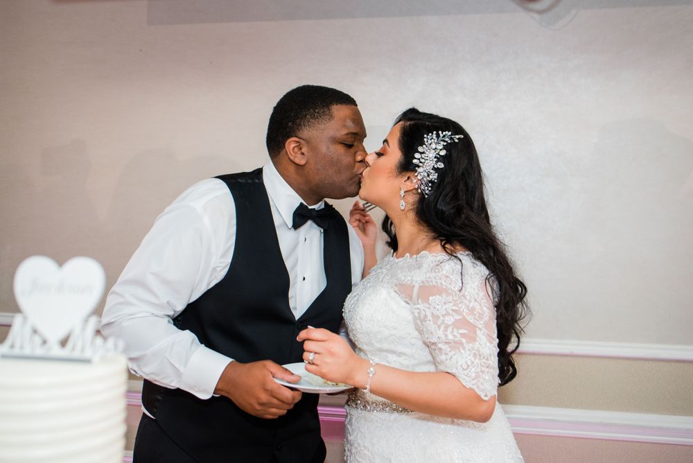 bride kissing groom cake cutting