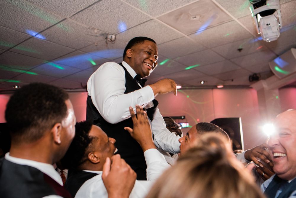 groom being picked up by wedding guest on the dance floor