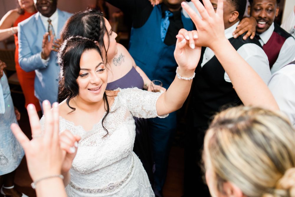 bride dancing with hands up in the air in the dance floor