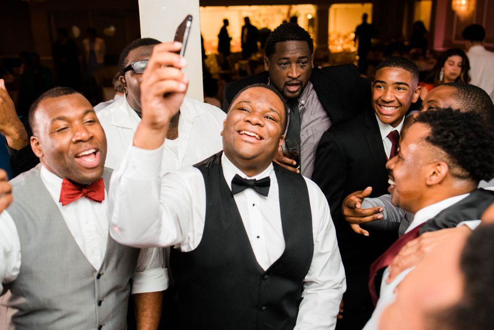groom taking a selfie with this friends on the dance floor