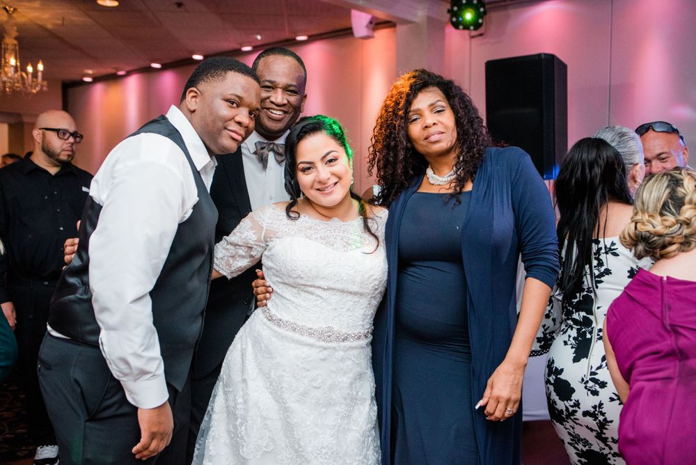 bride and groom posing with a wedding guest
