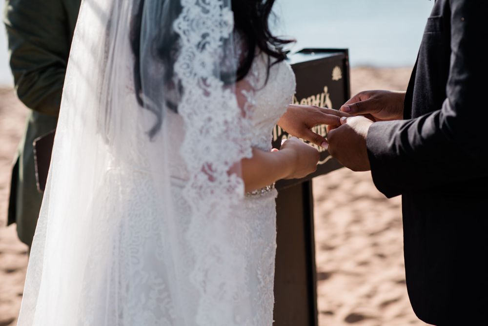 bride putting ring on grooms hand