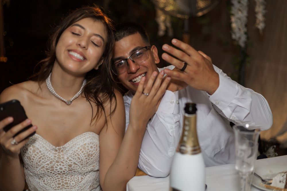 bride and groom showing off their rings
