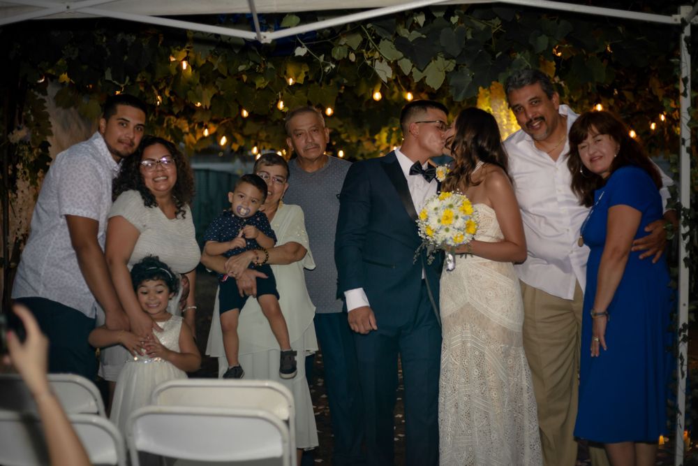 bride and groom's firs at the altar with family