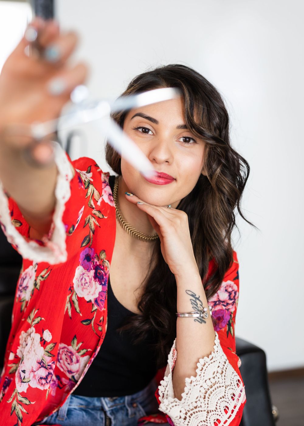 Stylish portrait featuring red floral kimono and playful pose with creative smoke effect.