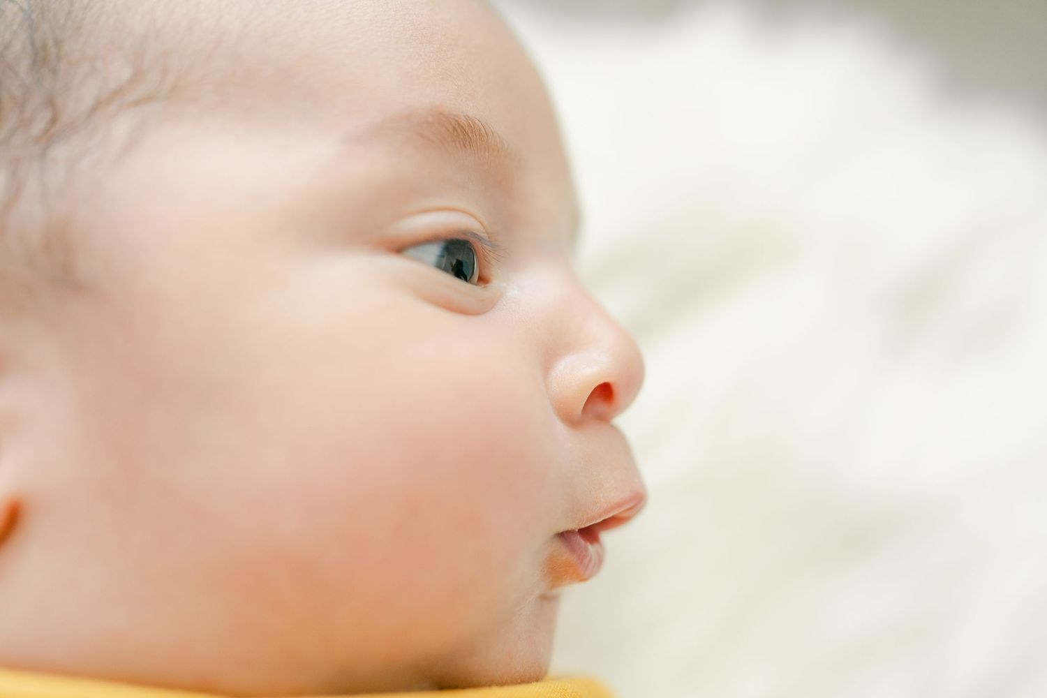 Close up profile view of a baby's face with soft focus and gentle lighting.