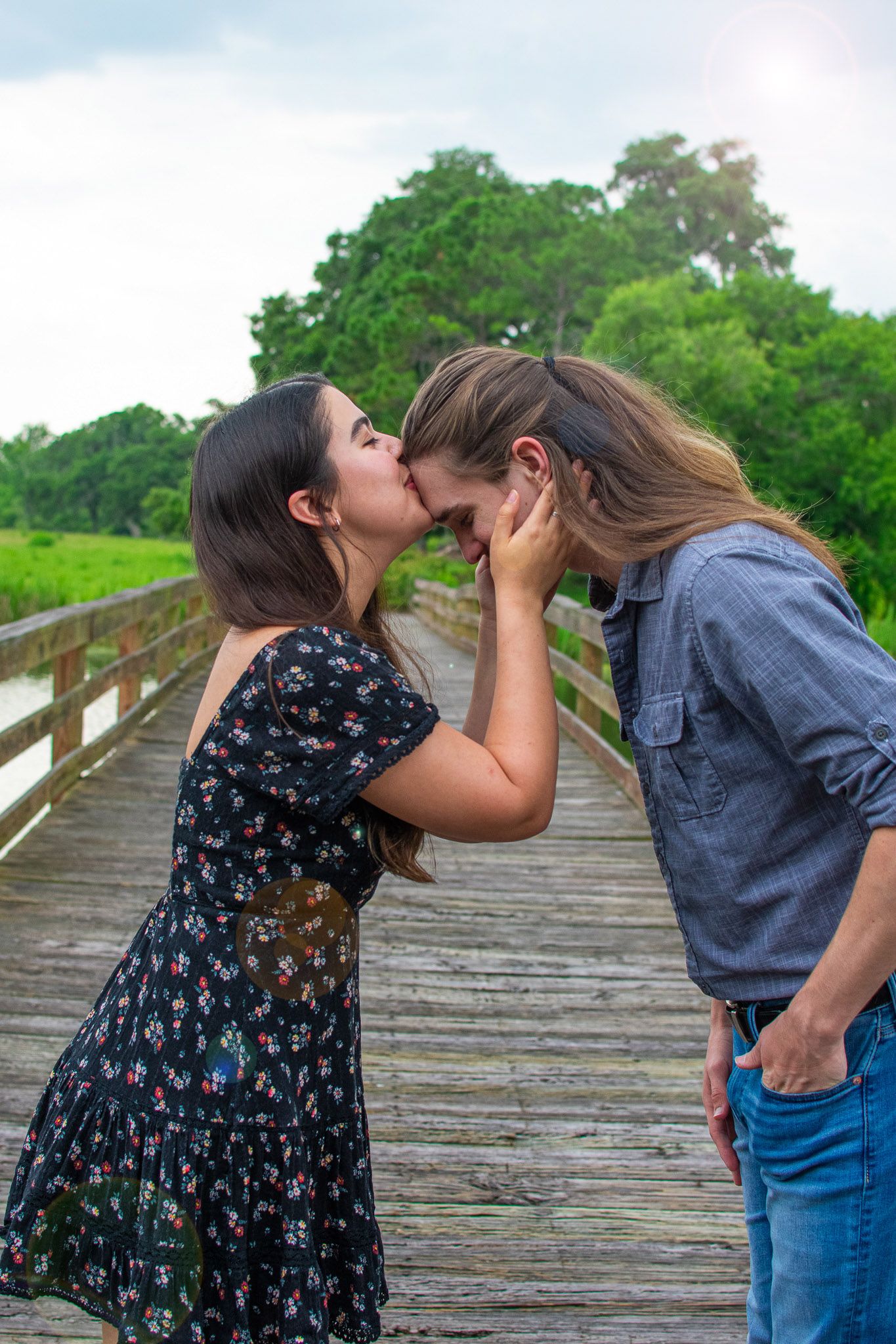 Intimate moment shared between couple on a wooden boardwalk.