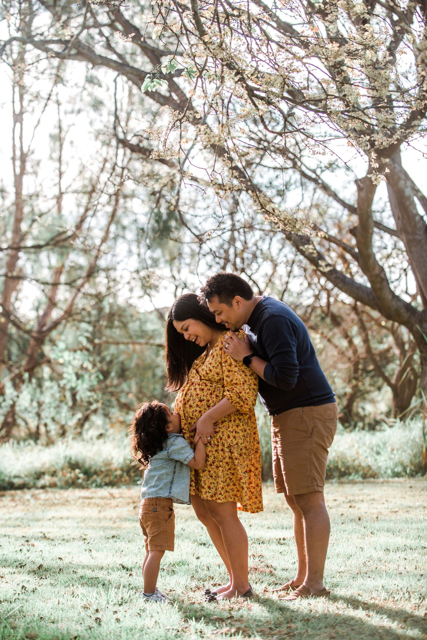 Family sharing intimate moment under blooming spring trees.