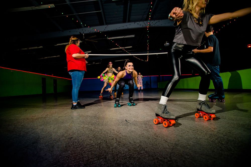 Group of roller skaters practice routine formations at indoor skating venue.