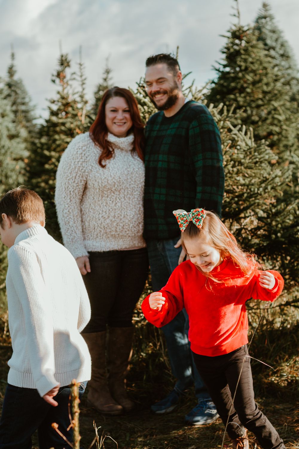 Playful family interactions captured against a backdrop of evergreen trees.