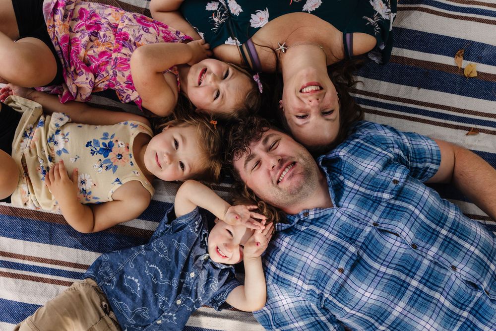 Playful family photo sequence on a striped blanket showing casual, relaxed moments together.