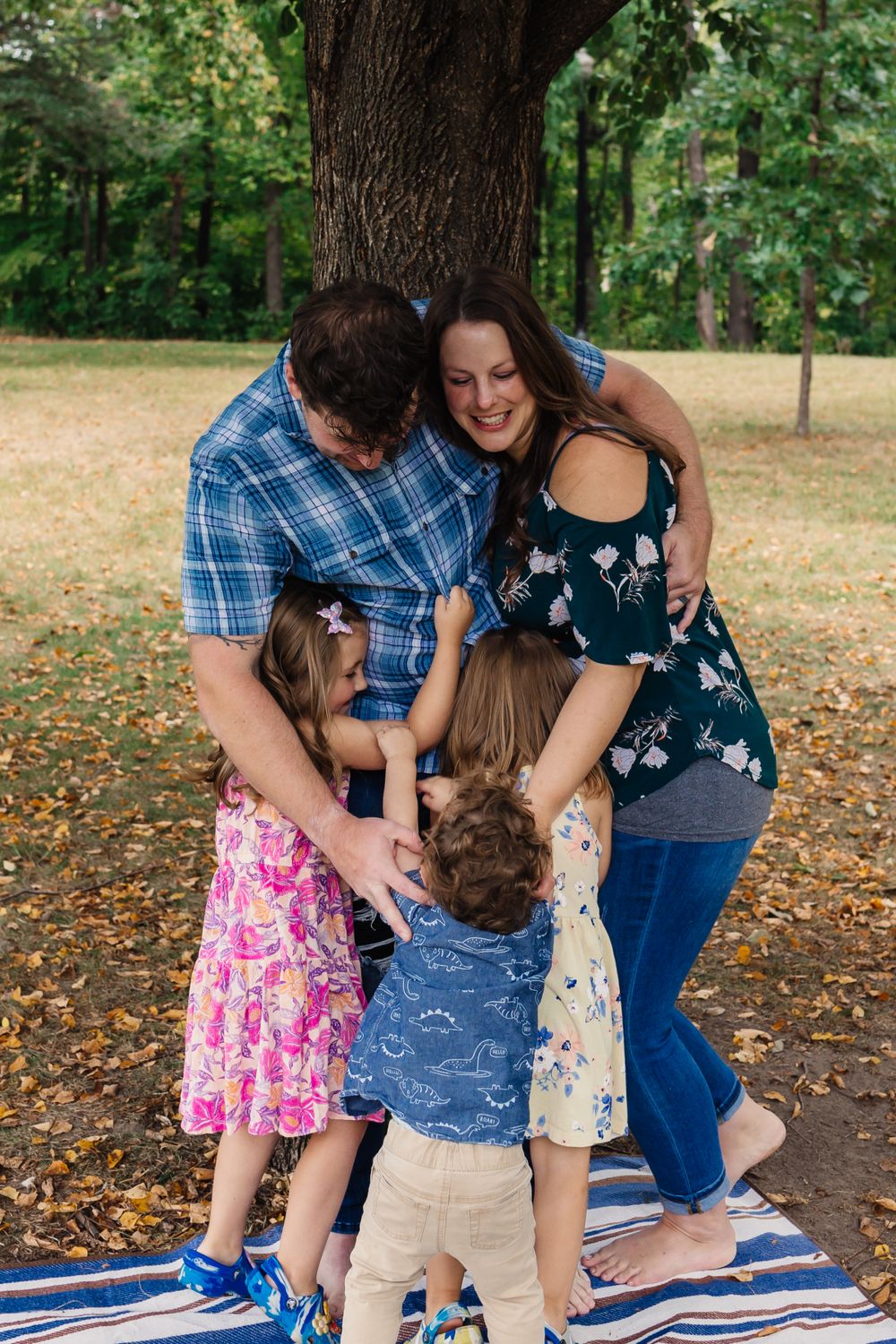 Sweet family interactions captured in sequence on a blanket under fall trees.