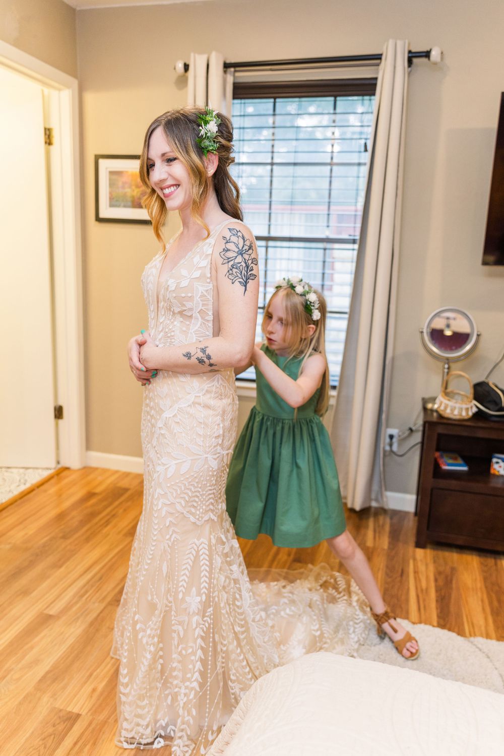 daughter of bride buttoning mother's wedding dress