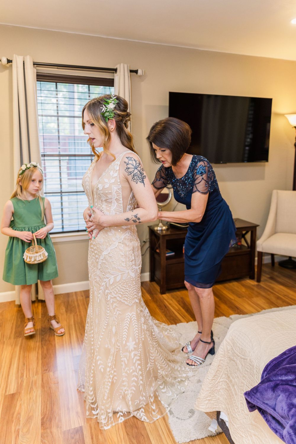 mother helping bride in dress