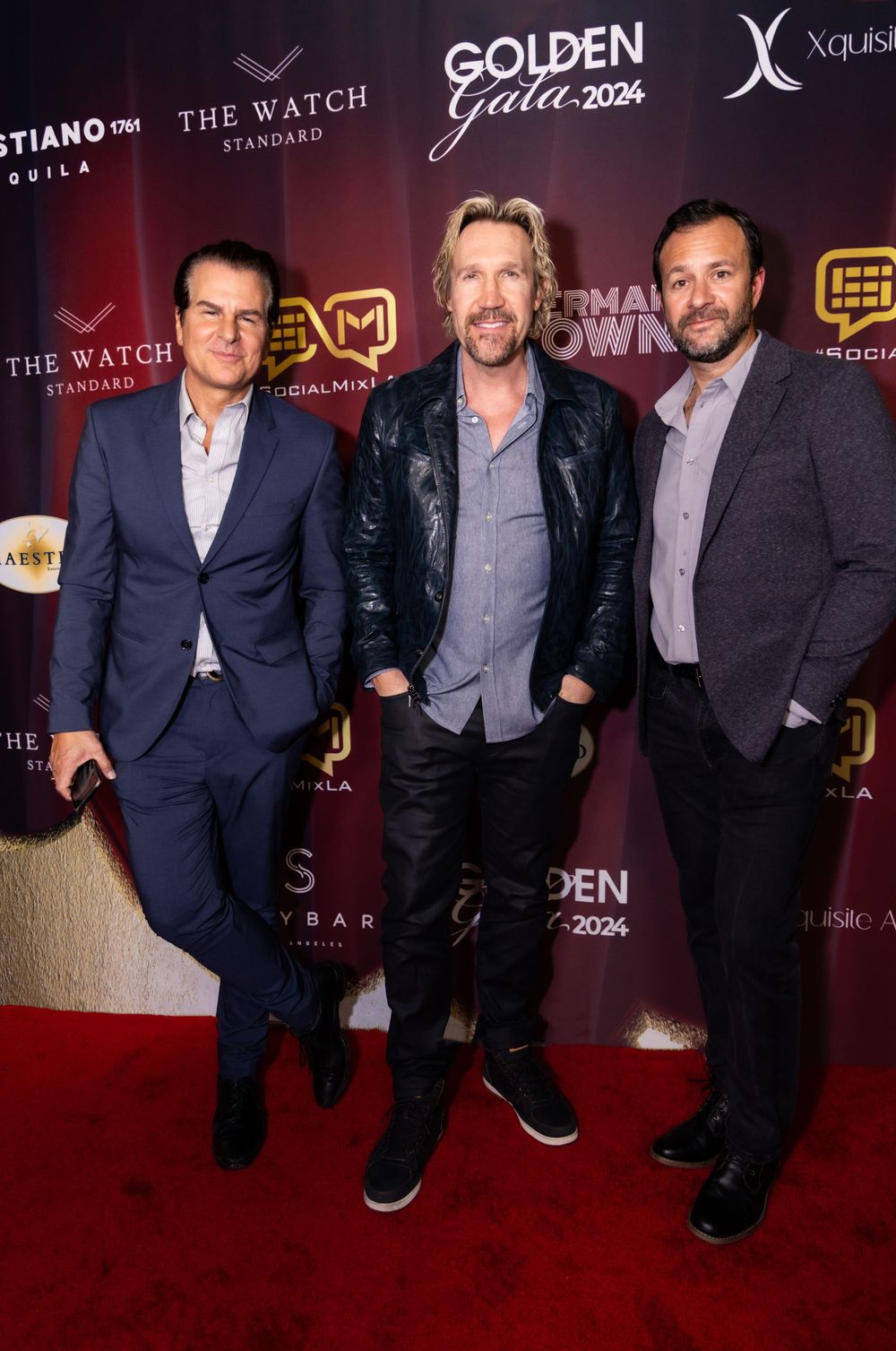Three people pose together on the red carpet at the Golden Gala 2024 event.
