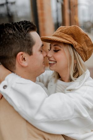Sweet romantic moment between couple in matching white and tan outfits.