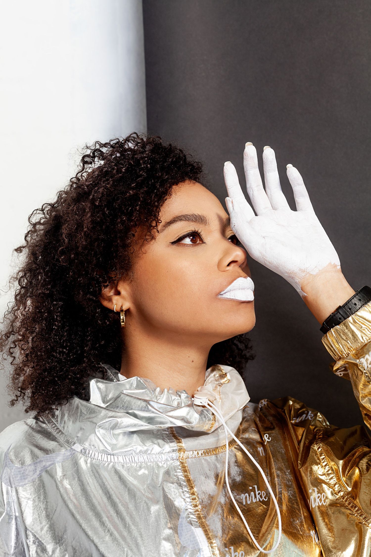 Studio fashion portrait with metallic jacket and white gloves creating elegant poses.