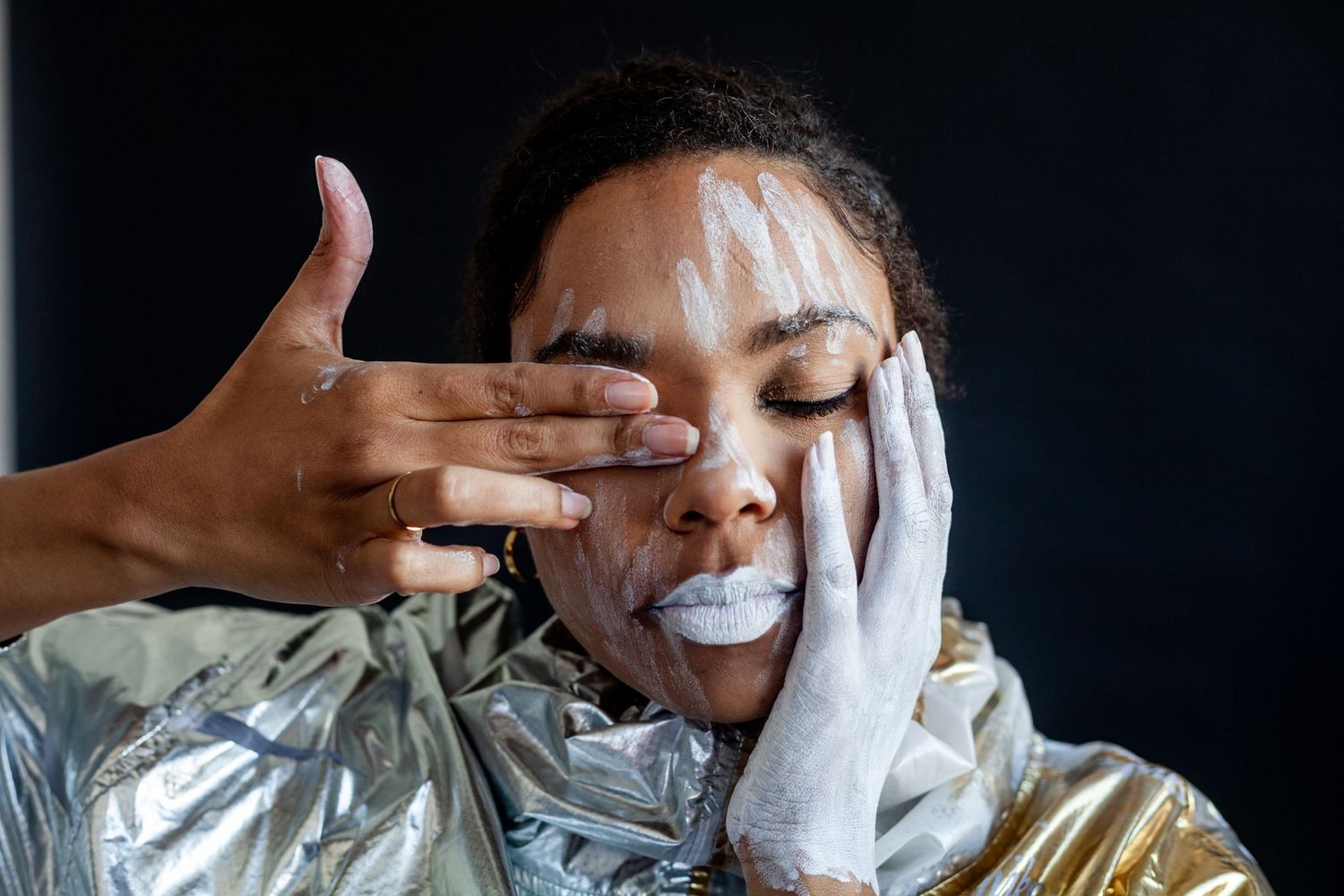 Close-up photo sequence showing hands with white gloves touching face against dark background.