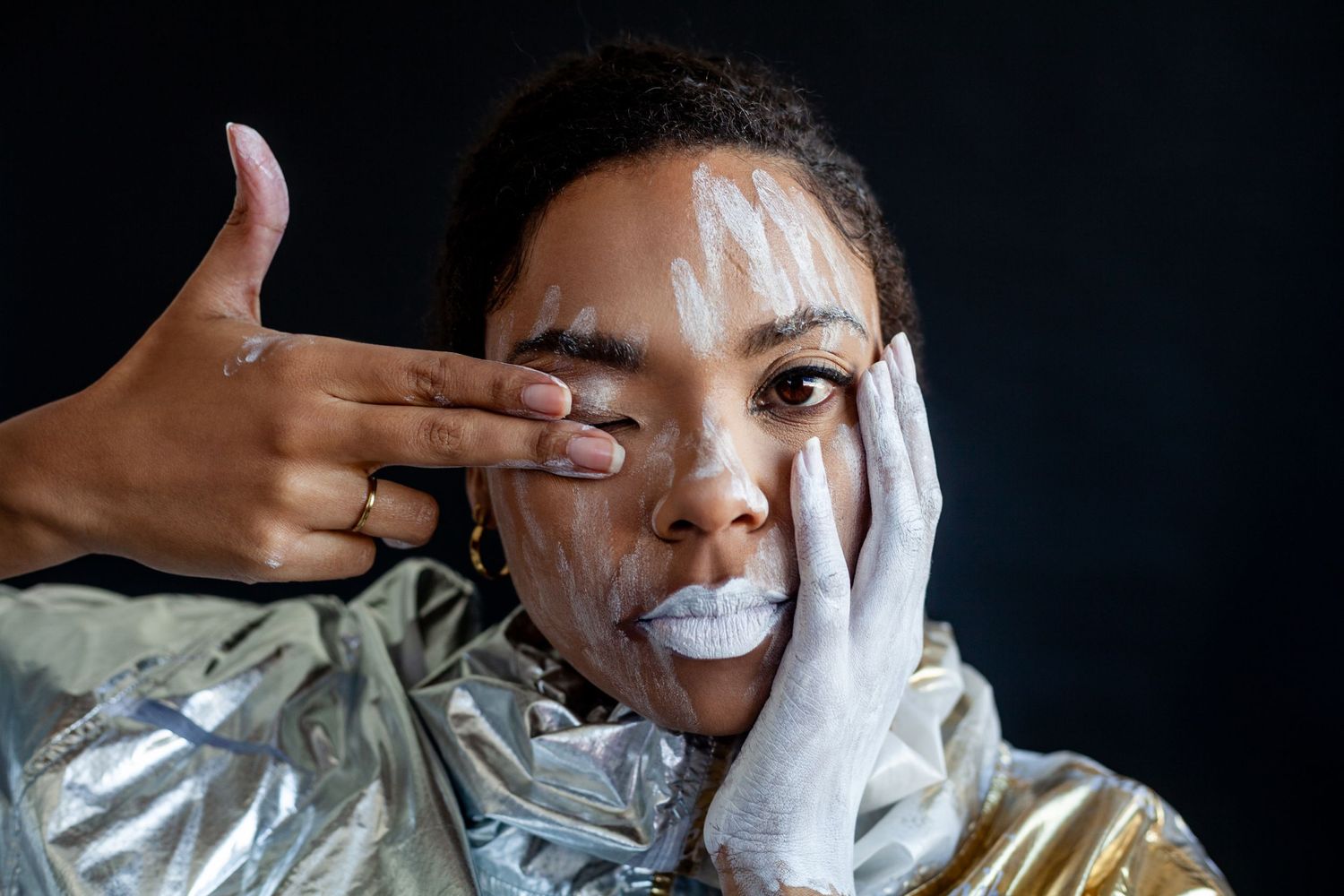 Artistic fashion series with metallic jacket and white gloves creating dynamic poses.