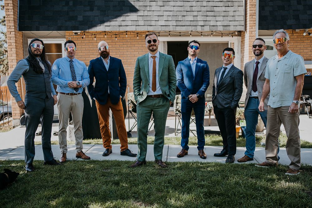 groom standing in the middle of his friends outside his house