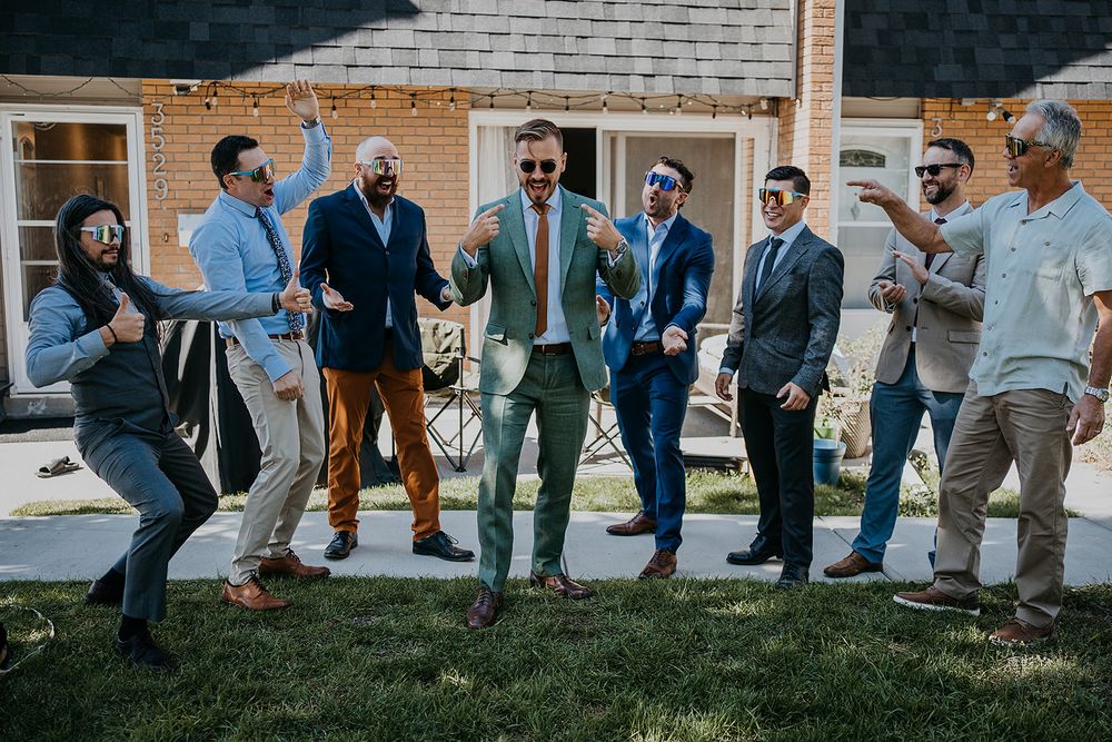 groom and his friends hyping him up for pictures outside his home