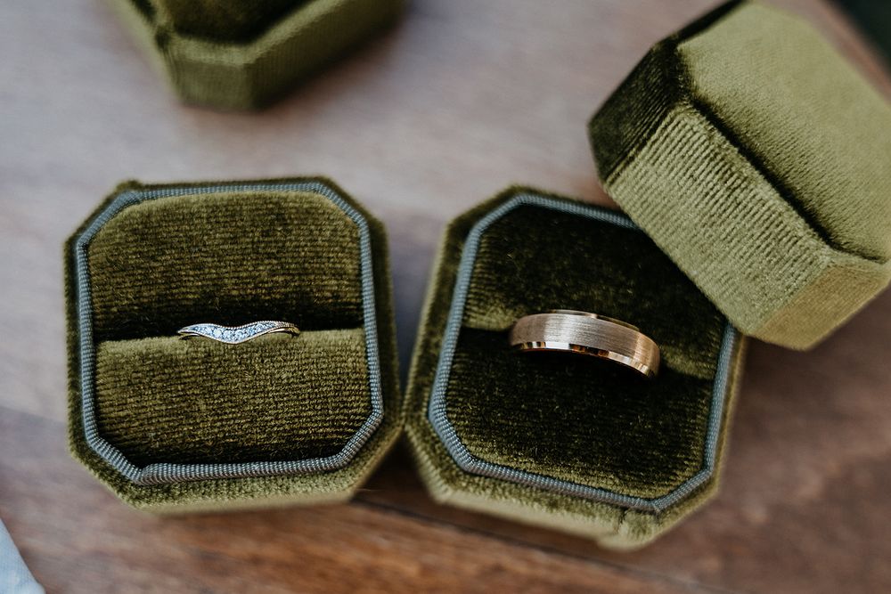bride and grooms rings in their green boxes