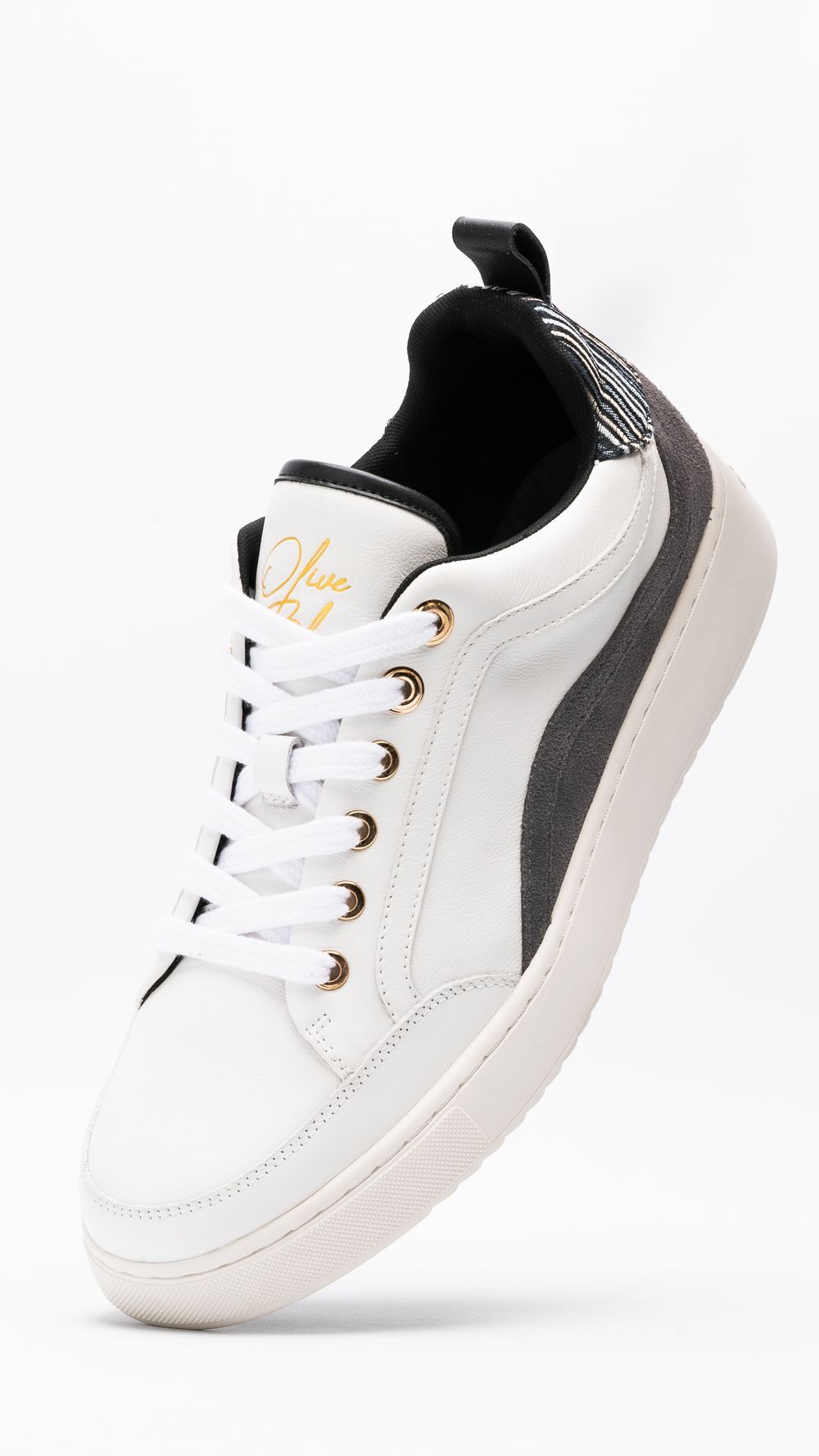 White and black athletic sneaker with gold accents against white background.