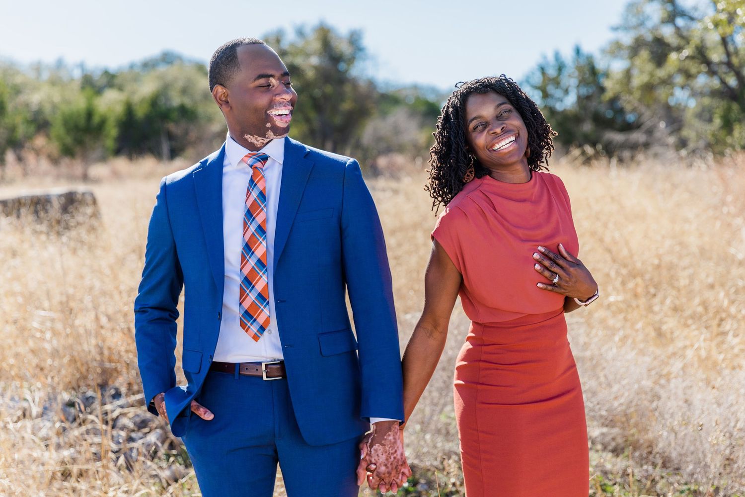 couple dressed formally standing in tall grass field