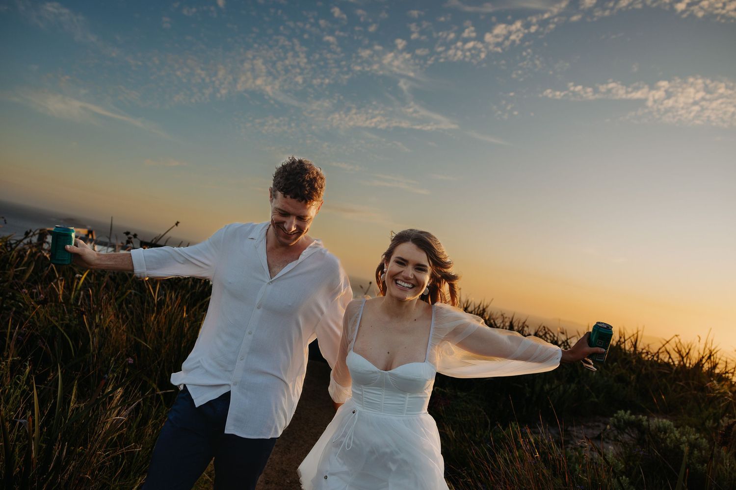 Silhouettes of a couple dancing together during golden hour in a natural outdoor setting.