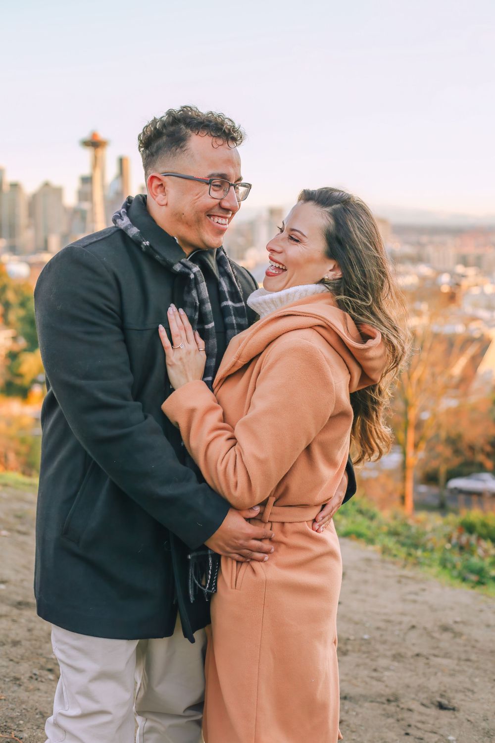 A couple sharing a joyful moment with the Seattle Space Needle visible in the background. Spokane Liberty Lake Photographer Family