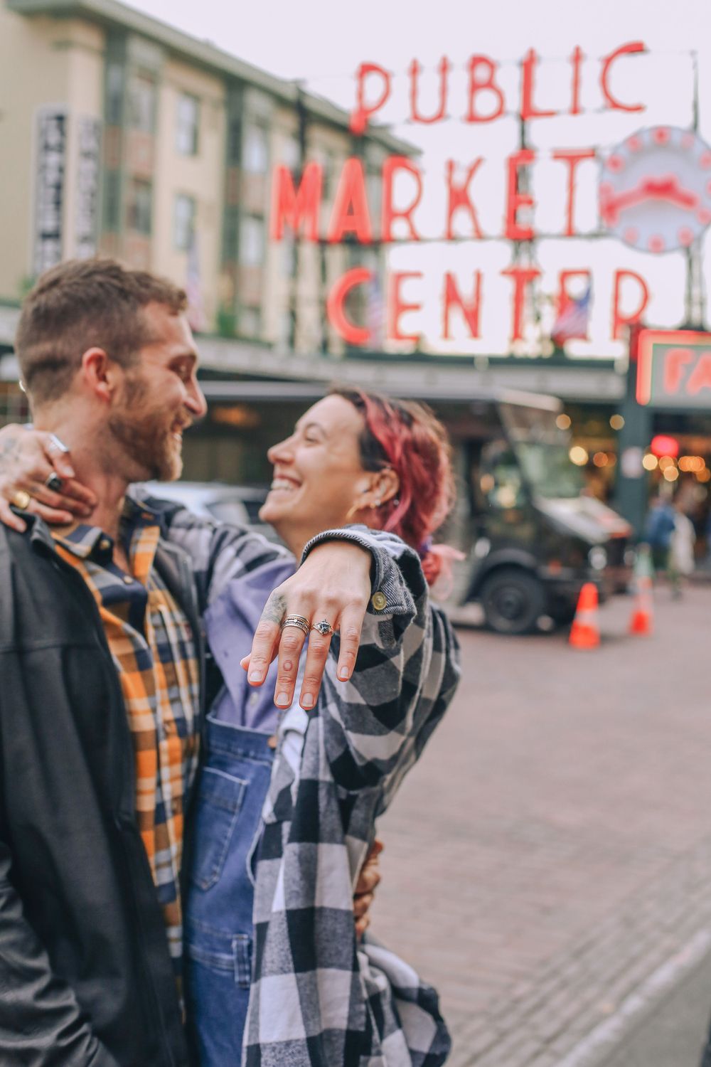 Couple sharing a romantic moment in front of the iconic Pike Place Market sign in Seattle. Spokane Liberty Lake Photographer Family Photogra
