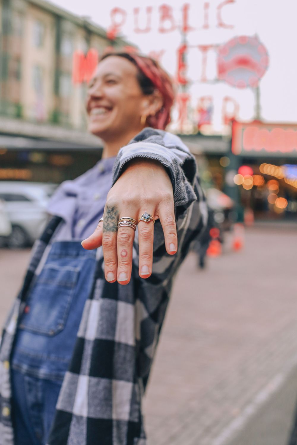 A close-up of a hand showing off an engagement ring at Pike Place Market. Spokane Liberty Lake Photographer Family Photographer