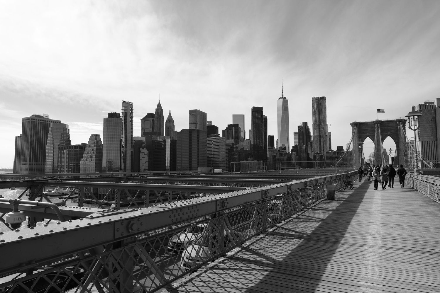 Dramatic view of Manhattan skyline from Brooklyn Bridge walkway.