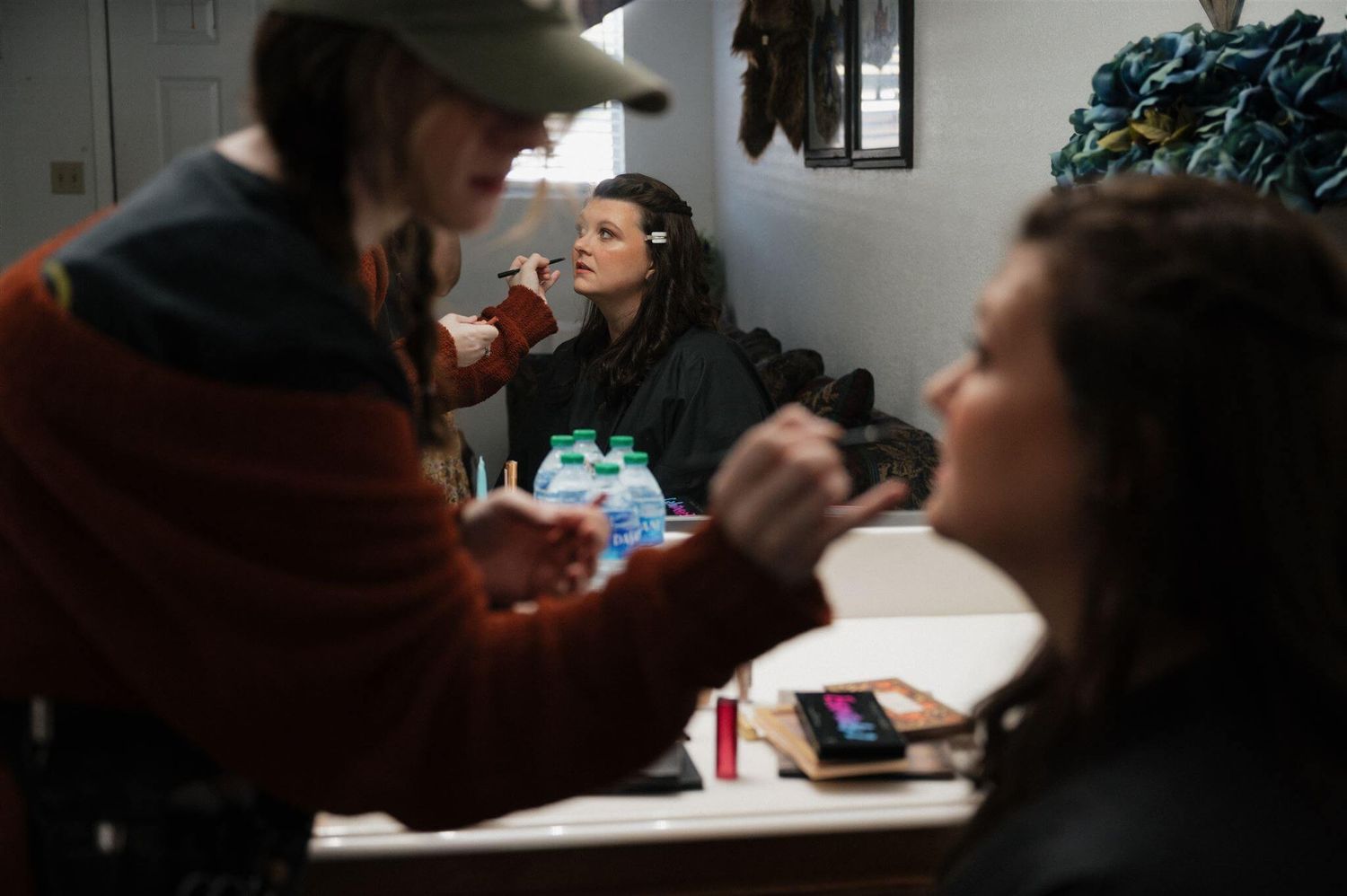 Behind the scenes makeup application in a preparation room.