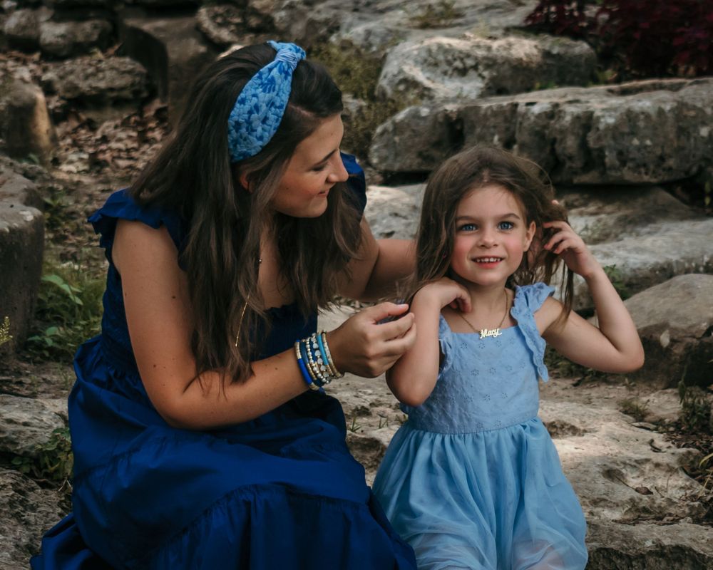 A mom helps her daughter fix her hair for the photo shoot