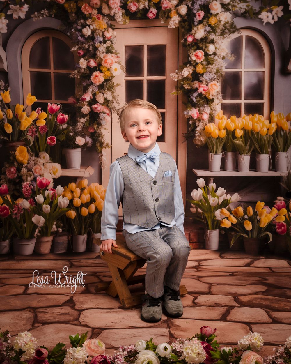 Spring portrait setup with flowers and arched windows featuring formal attire against floral backdrop.