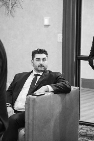 Black and white photo of guests lounging in formal attire at an elegant event.