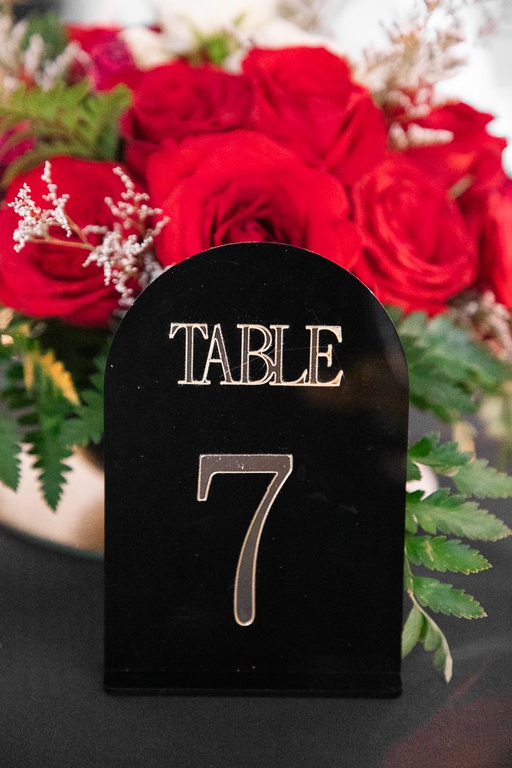 Table number seven displayed with red roses and floral arrangements.