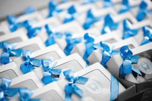 Close-up of party favors with blue ribbons arranged on a table.