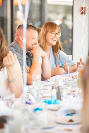 Guests seated at a decorated table enjoy conversation during a celebration.