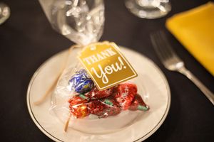 Small chocolates or candies arranged on white plates at an event.