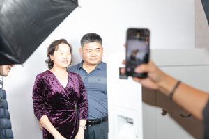 Behind the scenes photo shoot setup with lighting equipment and smartphone camera in studio setting.