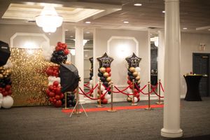 Elegant event space decorated with red velvet ropes and golden accents.