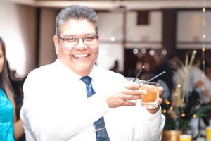 People raising glasses in a celebratory toast at an indoor event.