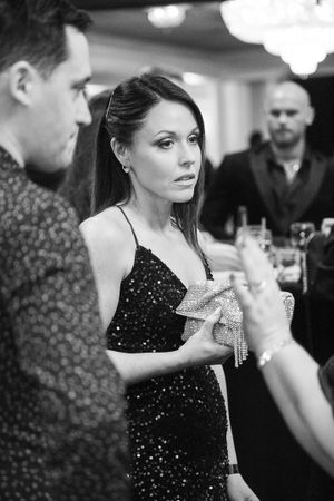 Guests in formal attire enjoying drinks and conversation at an elegant evening event.