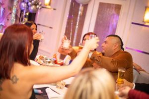 People celebrating at an elegant indoor event with warm lighting and festive decorations.