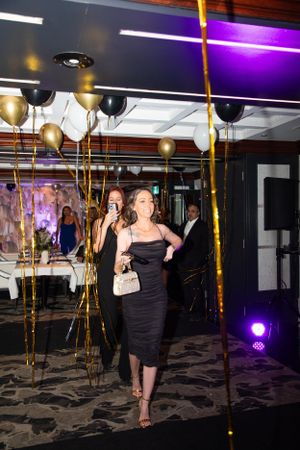 Party venue with gold balloon decorations and purple lighting creating a festive atmosphere.
