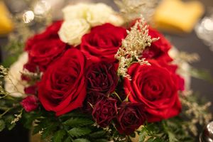 Close-up of red roses and gold baby's breath floral arrangement.